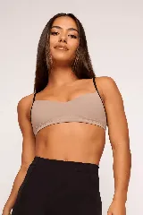 Top deportivo color beige con tirantes finos negros en contraste.