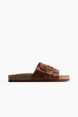 Sandalias marrones de cuero sintético con hebilla dorada ajustable y plantilla anatómica.