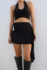 Minifalda marrón con drapeado lateral y detalle de hebilla dorada.