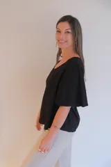 Blusa negra de tela liviana con escote en V y mangas cortas con volados.