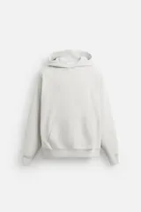 Sudadera con capucha gris confeccionada en tejido de algodón con interior rizo. Tiene manga larga, bolsillo frontal tipo canguro y acabados en rib.
