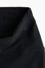 Calza de yoga negra de tiro alto, confeccionada en tejido funcional SoftMove™ con tecnología Lycra® Sport y DryMove™.