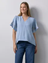 Blusa color beige de crepe, marca Batía, con cuello a la base y escote en V. Manga corta amplia con bordados.