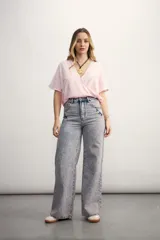 Blusa rosa de lino con escote cruzado en V y mangas cortas. Incluye un collar con cordón negro y dije dorado.