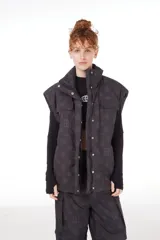 Chaleco negro con estampado de logos, cierre desmontable, broches snap ocultos, bolsillos frontales, elástico con tanca en la cintura e interior de tafeta relleno de guata.