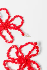 Par de aros colgantes con forma de flor, hechos de cuentas negras.