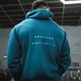 Canguro azul petróleo oversize unisex de algodón con felpa, con bordado en la espalda con la palabra "Ambition" y la leyenda "Since Oct. 23".