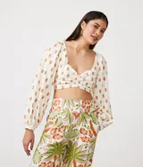 Blusa cropped de lino con escote corazón, lazada en la espalda, manga larga abullonada y estampado de anacardos.