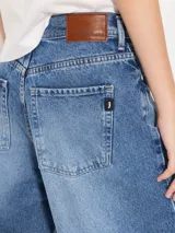 Pantalón de jean azul de corte ancho, estilo wide leg cropped, con lavado clásico y detalles de desgaste.