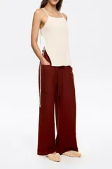 Pantalón de corte jogger color ladrillo, confeccionado en mezcla de lino, largo tobillero, con maxibolsillos tipo alforja. Cintura elástica pespunteada y ajustable con cordones de tejido.