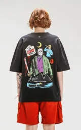 Remera negra de corte oversize con estampado de Jason Voorhees de Viernes 13, un letrero de Camp Crystal Lake tachado, y otros elementos de la película.