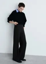 Pantalón de punto color beige, de corte wide leg, tiro medio y cintura elástica.