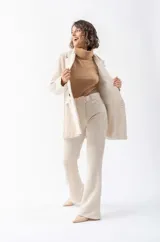 Pantalón de pana color beige con corte acampanado y cinturón con hebilla forrada.