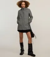 Saco largo con capucha y estampado pied de poule en blanco y negro. Tiene cuello alto, cierre con botones y cremallera, bolsillos y mangas largas.