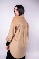 Sobrecamisa color beige de pana con cuello camisero, cierre frontal con botones a presión, dos bolsillos de parche en el pecho y corte holgado.