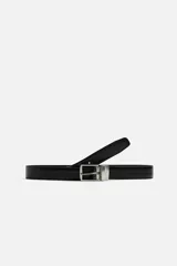 Cinturón reversible de cuero negro con hebilla metálica plateada.