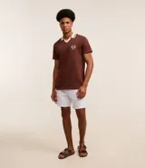 Camisa polo marrón con textura, cuello con detalle contrastante en beige y logo bordado en el pecho.