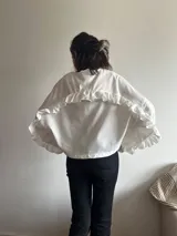 Camisa blanca con volados grandes en la espalda y mangas.