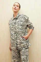 Sobrecamisa de calce amplio con estampado animal print, cuello camisero, cierre con botones, bolsillos frontales y ruedo redondeado.