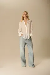 Pantalón de jean de tiro medio y silueta recta, con acabado brillante debido a un efecto transfer que simula incrustaciones.