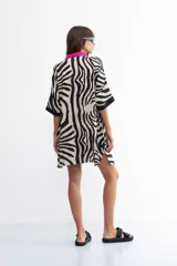 Vestido camisero con estampado de cebra, cuello camisero con vivos fucsia y corte holgado.