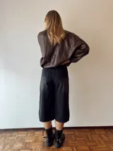 Bermuda de jean negro con corte ancho a la rodilla.