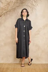Camisa extra larga negra, estilo vestido, con botones tipo prendedor dorados.