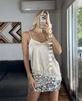 Musculosa lencera blanca con encaje, escote pico y tirantes finos. Bajo asimétrico.