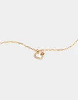 Cadena corta dorada con dije de corazón calado con strass.