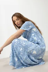 Maxi vestido celeste con estampado de hojas blancas y azules, de corte suelto y manga corta.