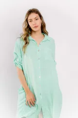 Vestido camisero largo color verde agua, confeccionado en lino. Tiene cuello camisero, mangas 3/4 con trabillas y botones, cierre frontal con botones y un bolsillo de parche en el pecho.
