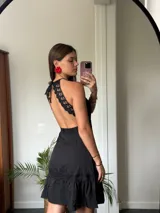 Vestido corto rojo con escote halter, corte a la cintura y falda con volados.