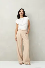 Pantalón sastrero color beige con finas rayas verticales, de cintura alta, corte ancho y pinzas frontales.