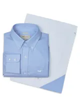 Camisa de manga larga celeste con finas rayas verticales blancas, de corte clásico y cuello abotonado. Tiene bolsillo en el pecho con logo de la marca bordado.