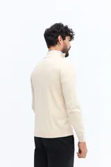 Sweater de tejido liso color verde oscuro, con cuello medio y cierre frontal parcial plateado. Presenta puños y cintura acanalados, y un pequeño logo bordado en el pecho.