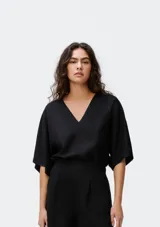 Blusa color crema con escote en V y mangas cortas amplias.