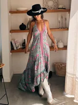 Vestido largo con estampado floral, escote halter y corte asimétrico con volados.