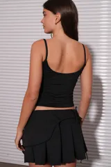 Top color moca con breteles finos y escote recto.