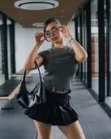 Remera gris de tejido de punto acanalado, con cuello redondo, mangas cortas con detalle desflecado y bajo con roturas.