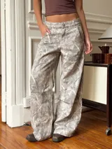 Pantalón baggy gris con estampado abstracto en tonos beige y blanco.