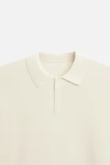 Polo marrón de punto con hilatura de algodón, corte relaxed fit, cuello solapa con cierre frontal de botonadura, manga larga y acabados en rib.