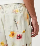 Bermuda boardshort color beige con estampado floral en tonos naranja y rosa.