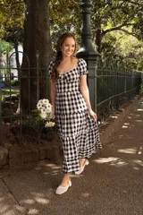 Vestido midi con estampado a cuadros blanco y negro, escote corazón con detalle de puntilla y mangas cortas abullonadas.