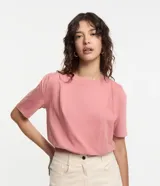 Remera rosa de algodón con cuello redondo, manga corta, pliegues en los hombros y elástico en el bajo.