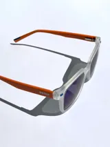 Lentes de sol negros con marco cuadrado y detalles rojos. Lentes con protección UV 400 y tecnología polarizada. Marca Osten, modelo Bali 2602.