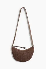 Cartera bandolera marrón de paja trenzada con correa del mismo material y cierre superior con tirador largo.