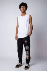 Pantalón de jogging gris claro con puños elásticos, cintura con cordón ajustable y estampado con motivos geométricos en la pierna izquierda.