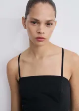 Vestido corto negro con tirantes finos y escote recto.