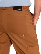 Pantalón de hombre color marrón, de corte recto, con cierre de cremallera y botón. Incluye bolsillos laterales, traseros tipo parche, trabilla para martillo y bolsillo utilitario en la parte trasera del muslo.