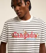 Remera de hombre a rayas horizontales blancas y negras, de corte recto y manga corta. Estampado frontal con el personaje Gruñón de Blancanieves y el texto "Zangado".